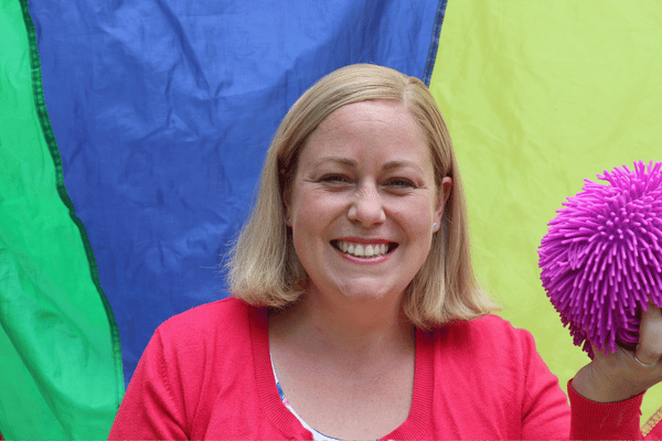 Woman smiling with brightly coloured background.